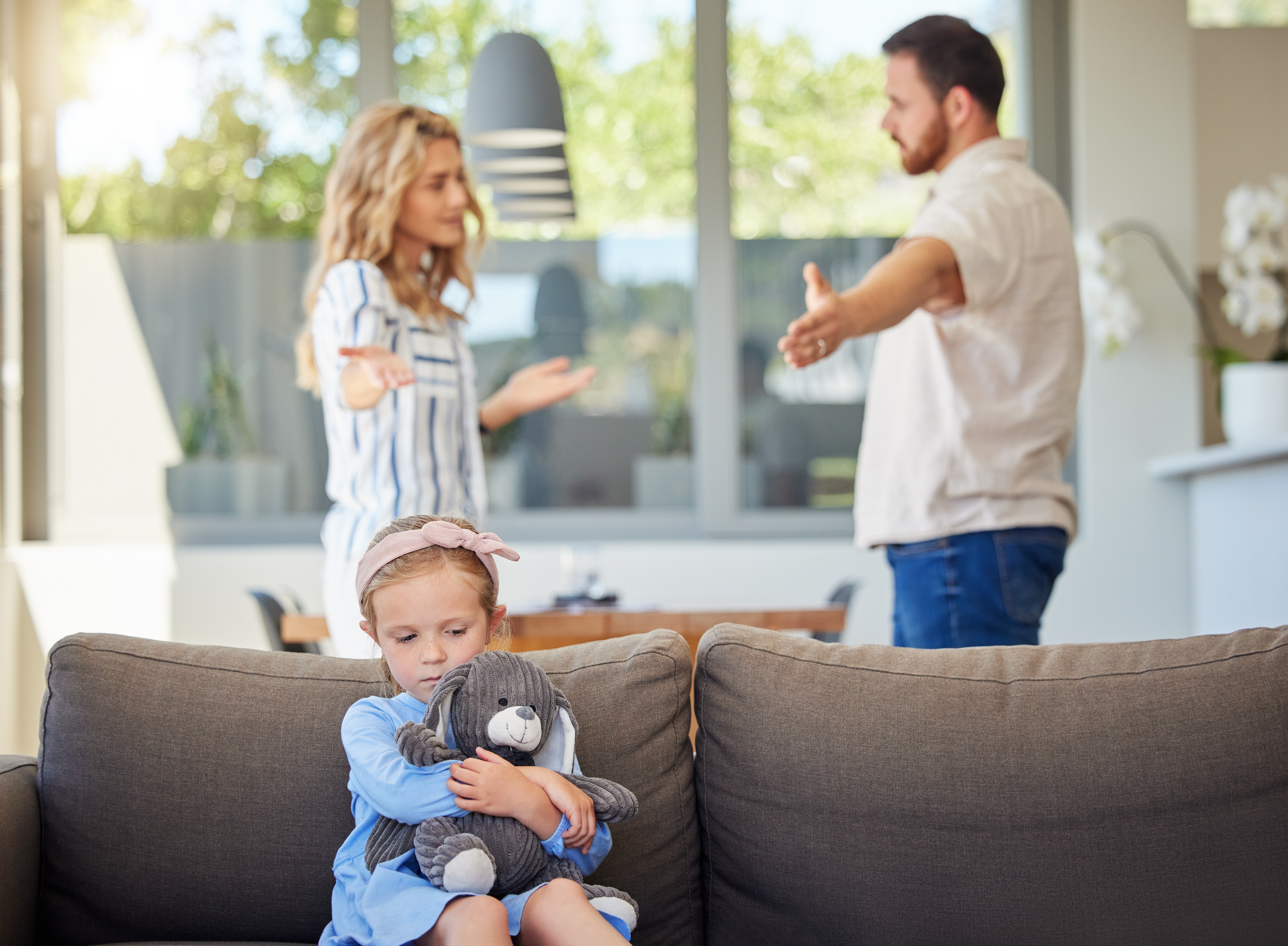 A scared little girl hearing her parents argue in the background | Source: Shutterstock