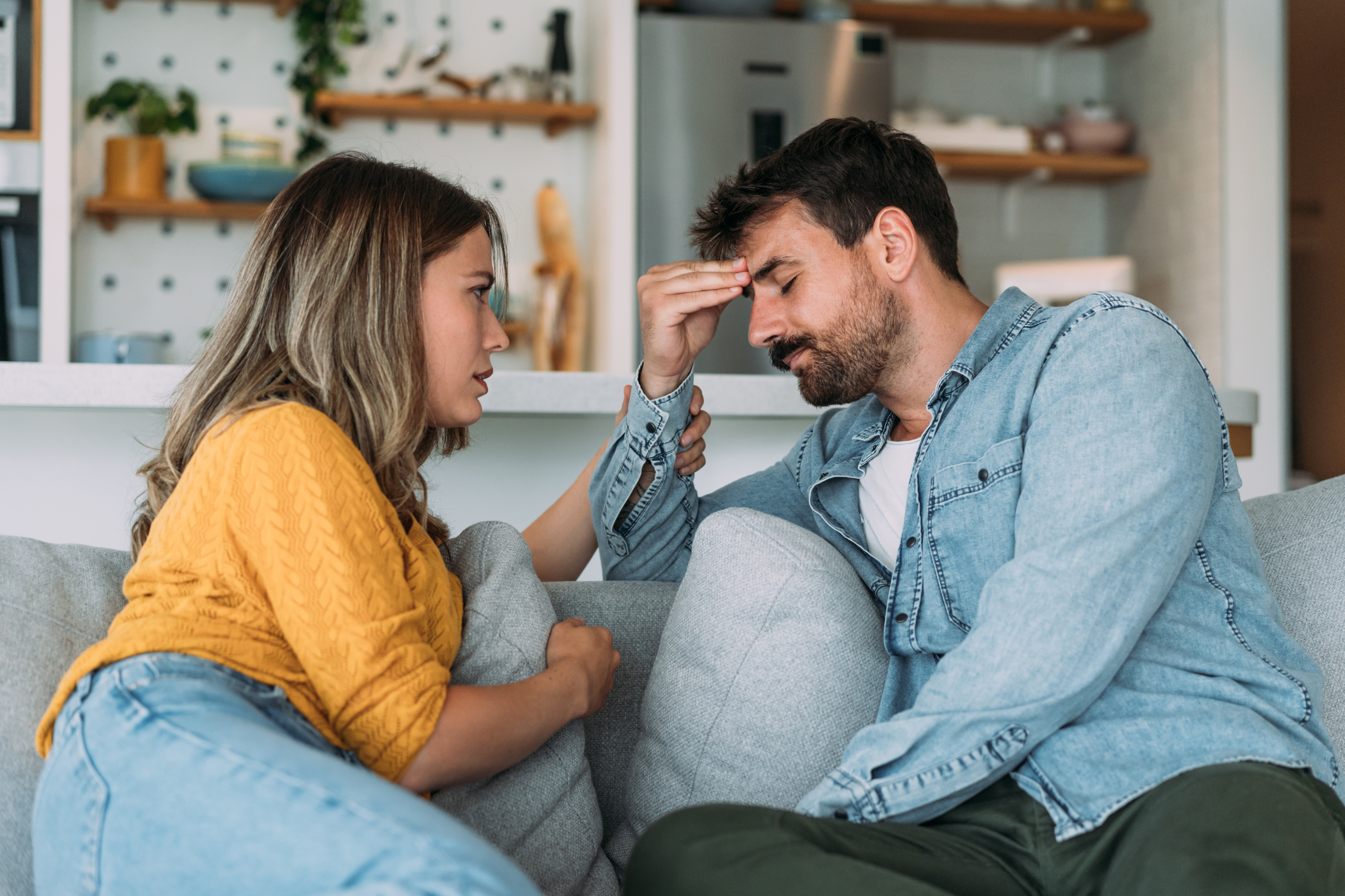 Worried couple talking together in the living room at home | Source: Getty Images