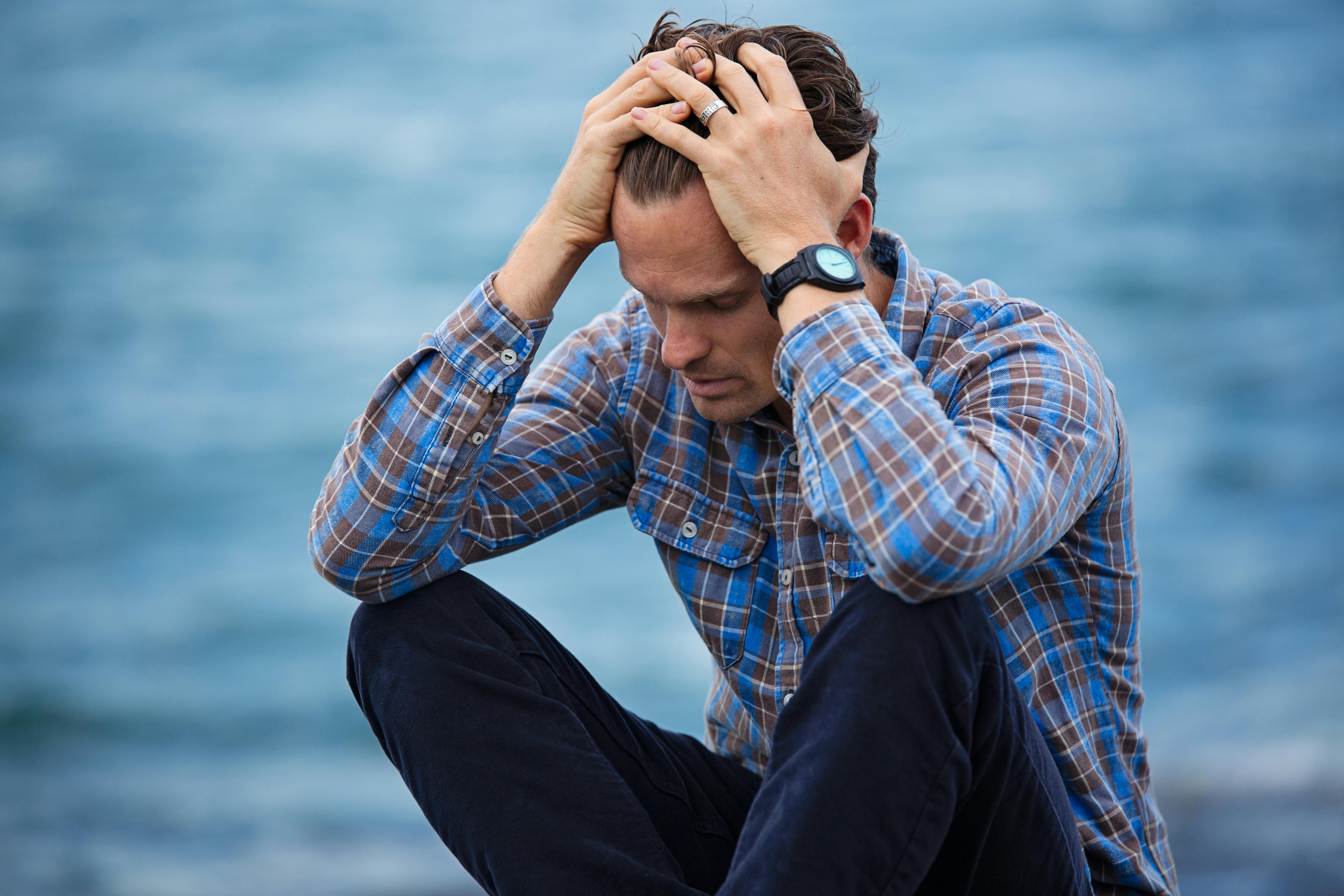 An upset man sitting on the floor outside | Source: Pexels