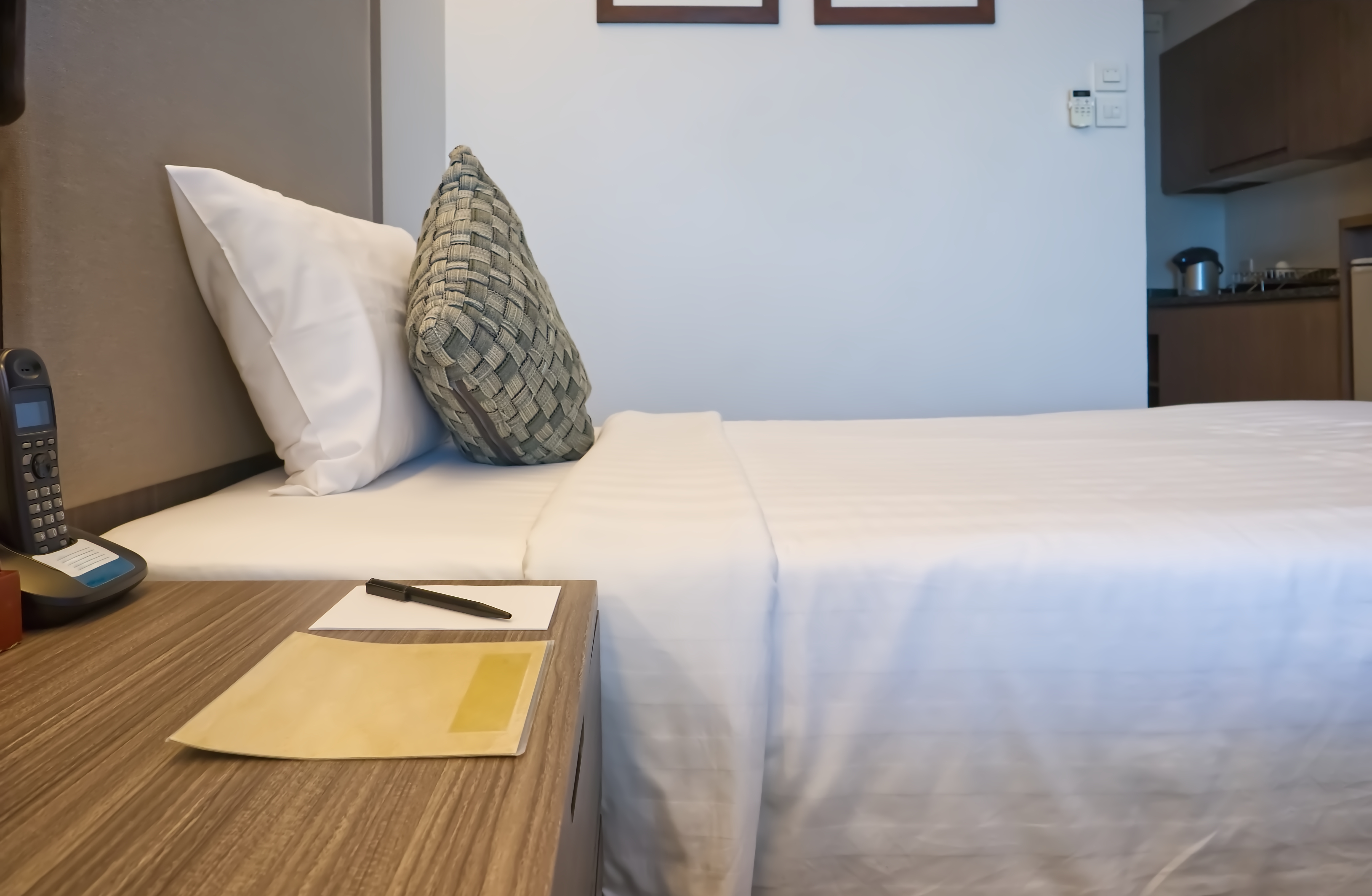 A notepad and pen next to a bed | Source: Shutterstock