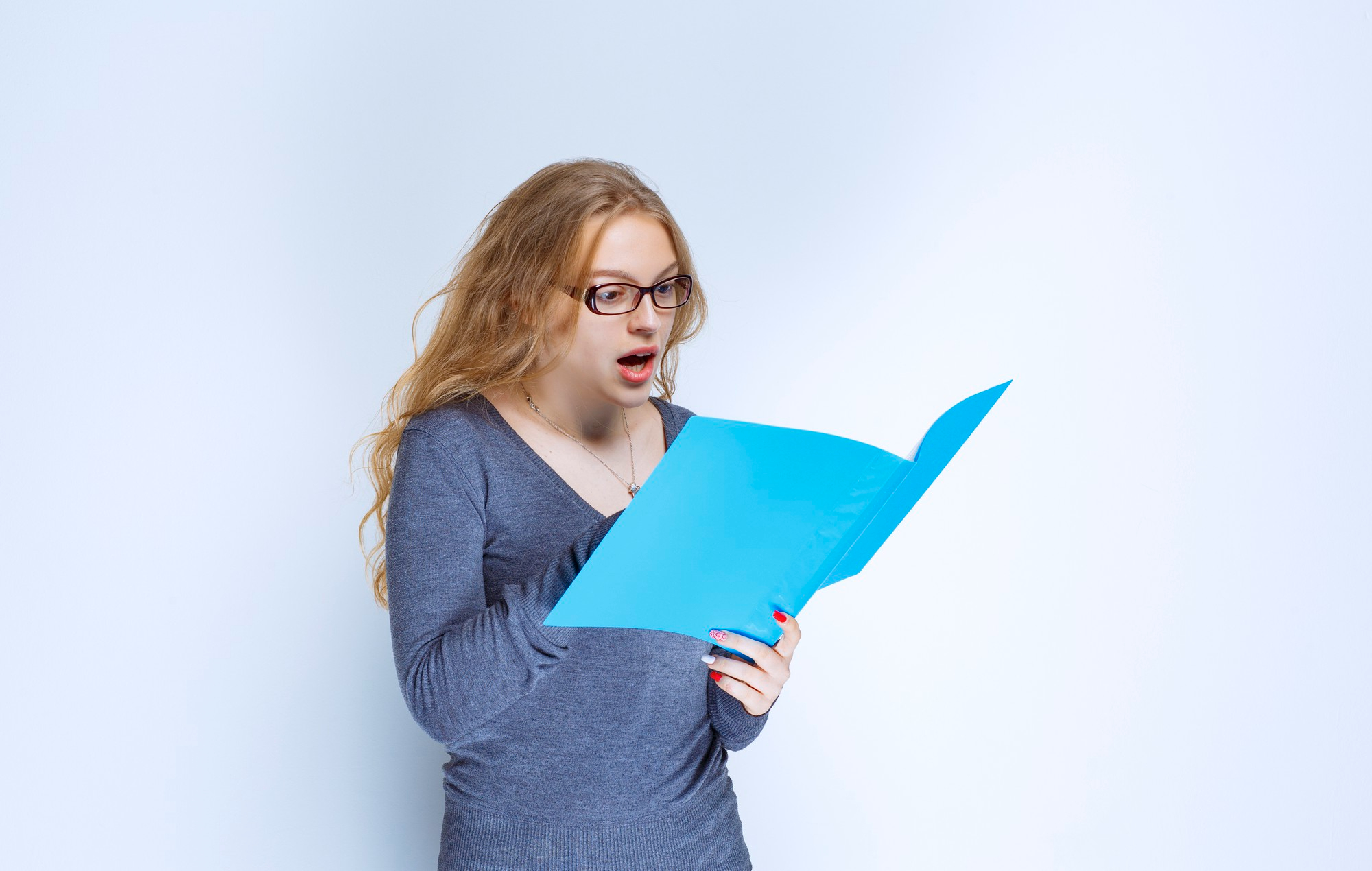 A shocked woman reading something in a folder | Source: Freepik