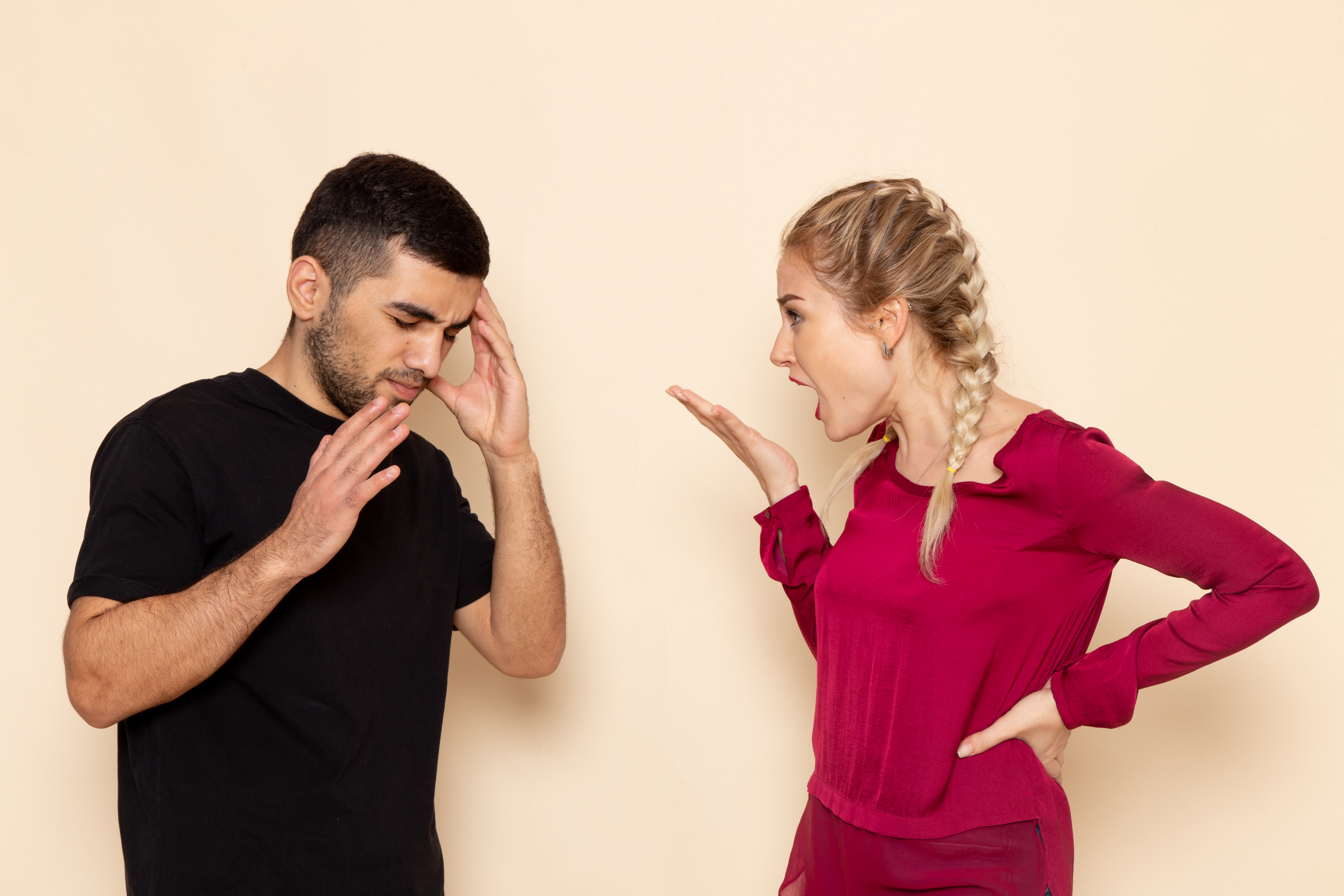 Woman gesturing to a man who looks confused | Source: KamranAydinov on Freepik