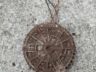 Heavy round metal object buried in yard, SE USA. Solid plastic cover with 4 wires sticking out.