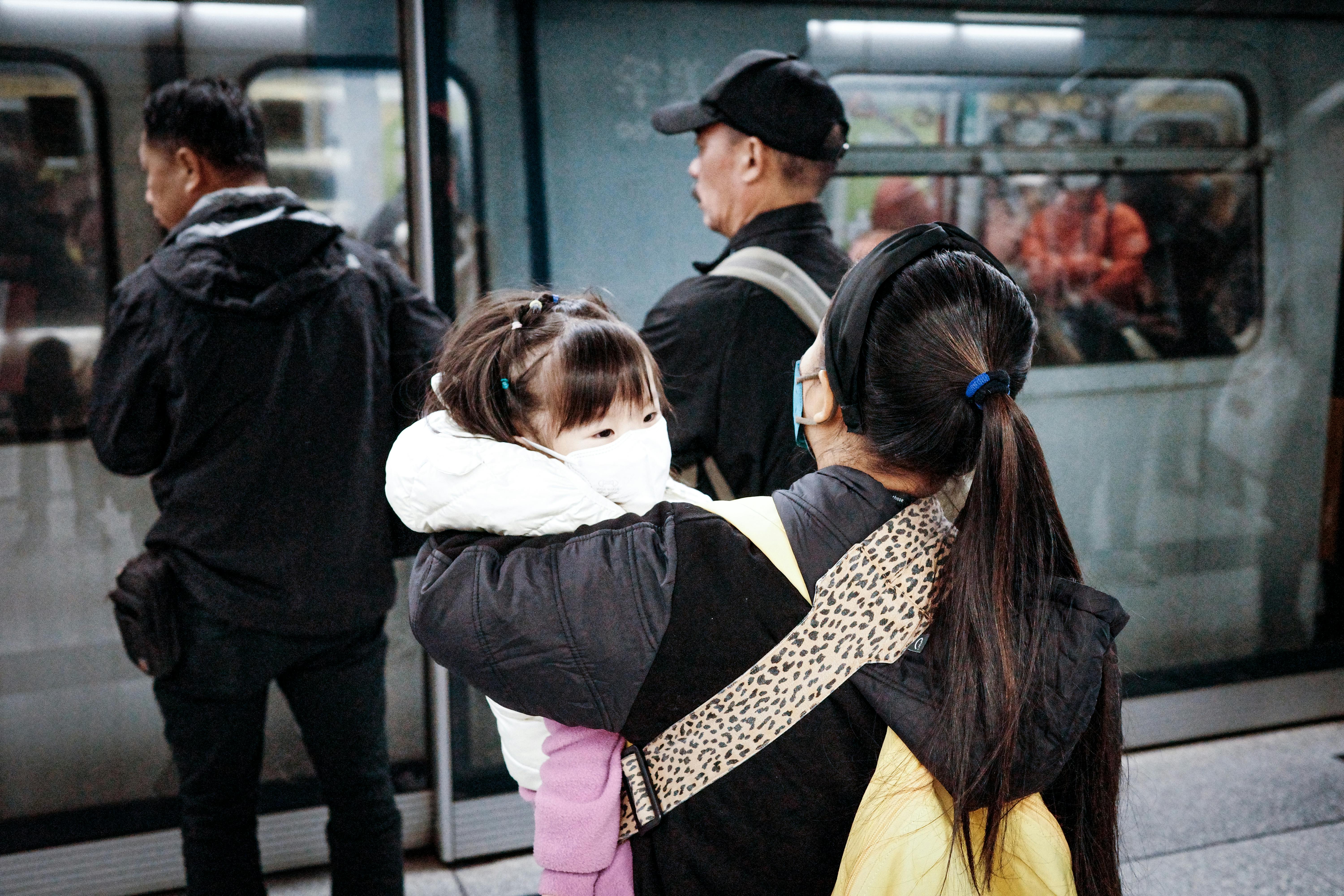 A woman holding a child about to board the subway | Source: Pexels