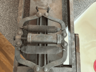 Found in a house constructed in 1950, this metal and spring device has springs, hinges, and a handle on the moving component. It weighs about 15-20 lbs and has a perimeter of roughly 12×5 inches.